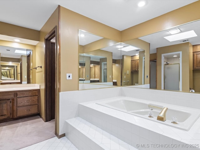 full bathroom with vanity, a garden tub, a stall shower, and visible vents