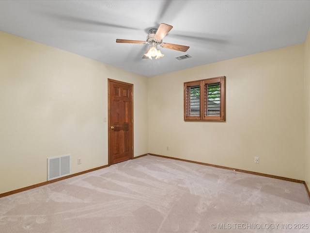 spare room with baseboards, light carpet, a ceiling fan, and visible vents