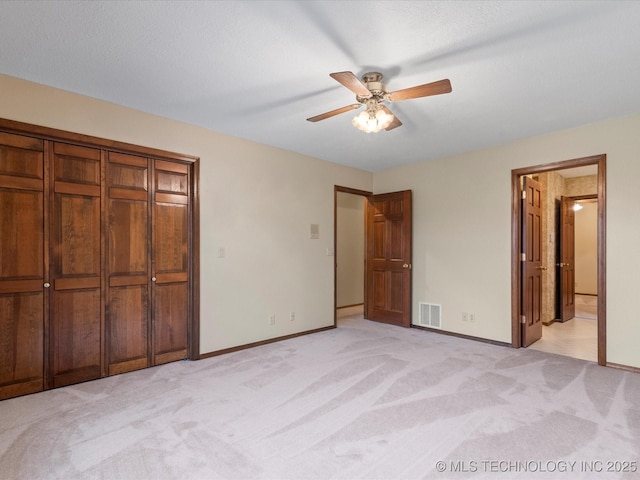 unfurnished bedroom featuring light colored carpet, baseboards, and visible vents