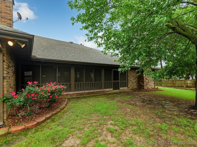 view of yard featuring fence and a sunroom