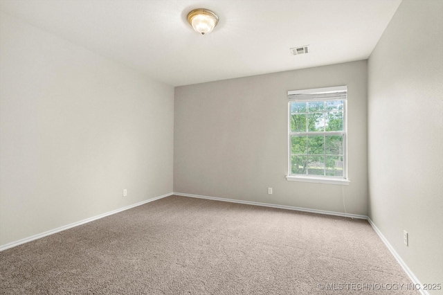 spare room with baseboards, visible vents, and carpet