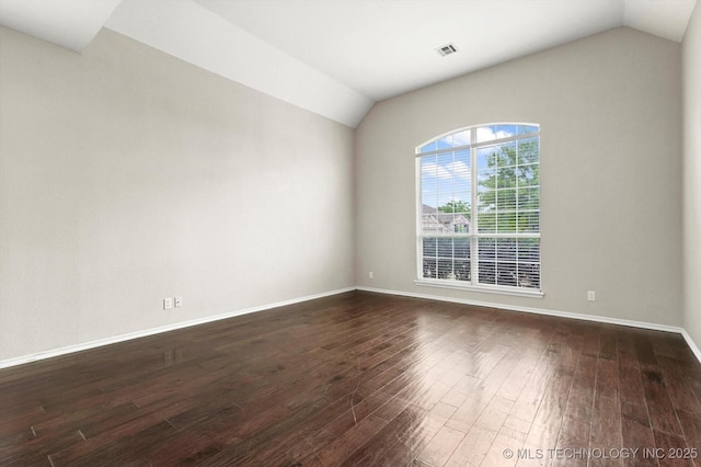 unfurnished room with dark wood-type flooring, baseboards, lofted ceiling, and visible vents