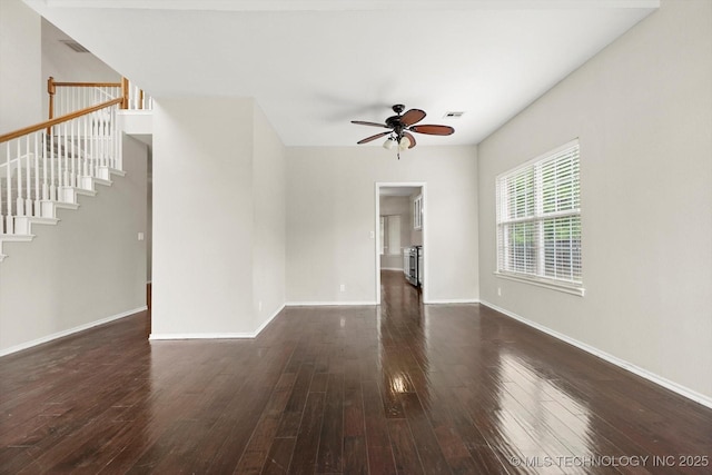 unfurnished living room with ceiling fan, visible vents, baseboards, stairs, and hardwood / wood-style floors