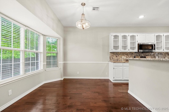 kitchen with decorative backsplash, dark wood-style floors, glass insert cabinets, stainless steel appliances, and white cabinetry