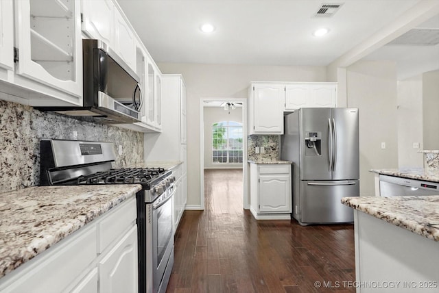 kitchen with white cabinets, appliances with stainless steel finishes, dark wood-type flooring, visible vents, and glass insert cabinets