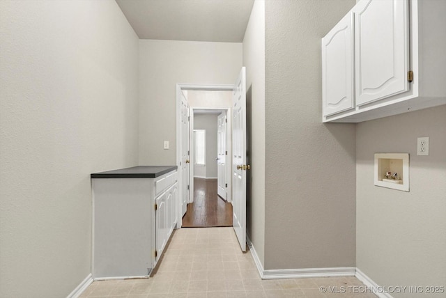 laundry area with baseboards, cabinet space, and washer hookup