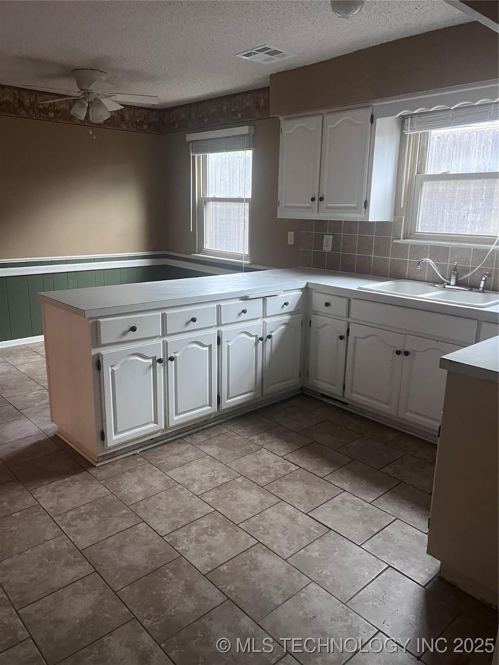 kitchen featuring light countertops, white cabinets, and a textured ceiling