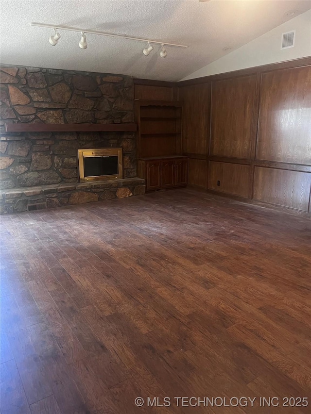 2640 W Fort Worth Pl, Broken Arrow, OK 74012 - below grade area featuring dark wood-style flooring, a stone fireplace, rail lighting, and a textured ceiling