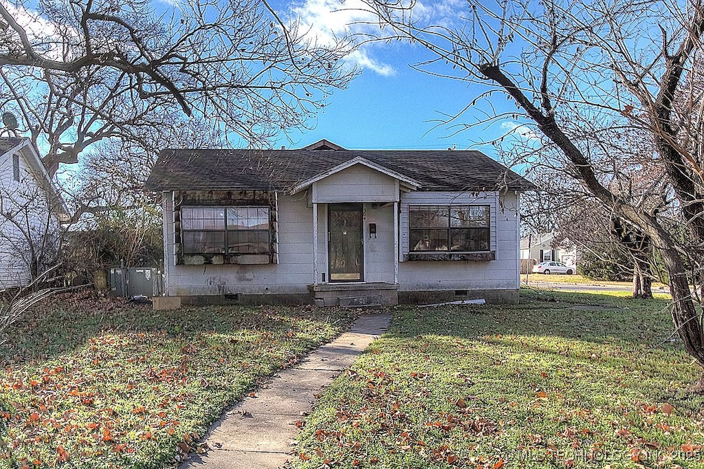 bungalow featuring a shingled roof, a front yard, and crawl space