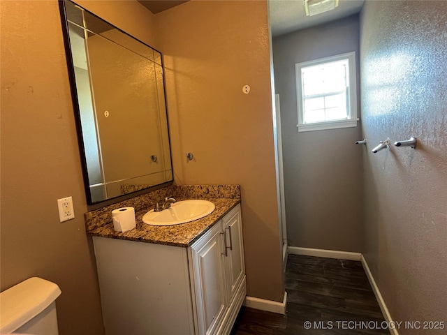 304 E 45th Ct, Tulsa, OK 74105 - bathroom with wood finished floors, baseboards, vanity, and toilet
