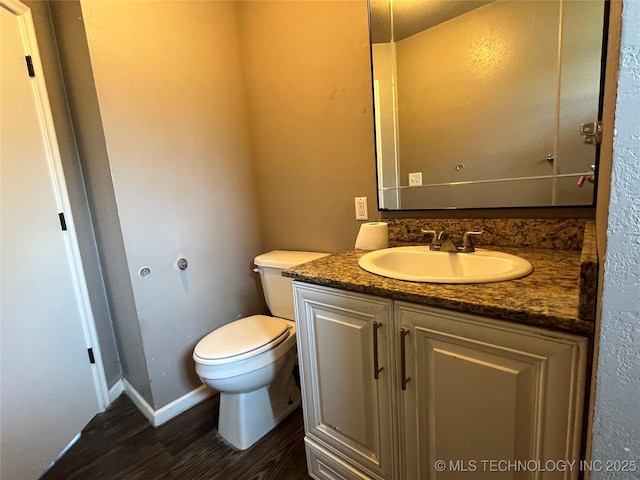 304 E 45th Ct, Tulsa, OK 74105 - half bathroom with wood finished floors, toilet, vanity, and baseboards