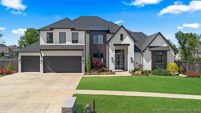 view of front facade featuring fence, a front yard, stucco siding, a standing seam roof, and driveway