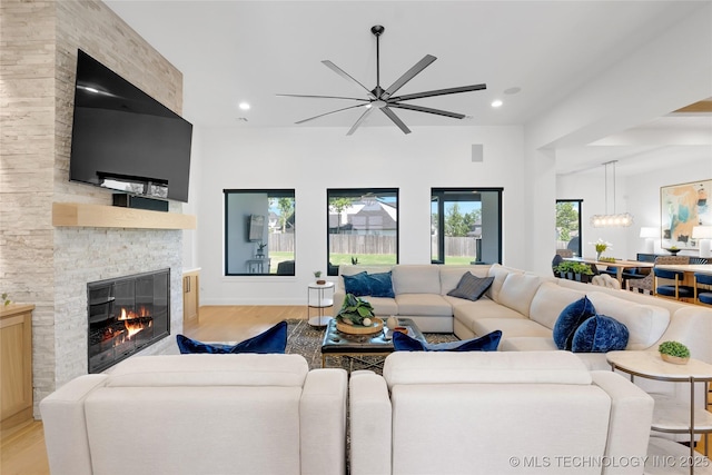 living area featuring recessed lighting, a fireplace, a ceiling fan, and light wood finished floors
