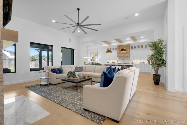 living area featuring a ceiling fan, visible vents, baseboards, light wood finished floors, and recessed lighting