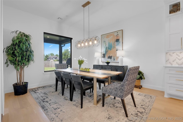 dining space featuring baseboards, visible vents, and light wood-type flooring