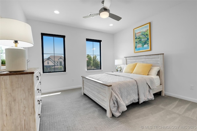 bedroom featuring baseboards, multiple windows, and light carpet