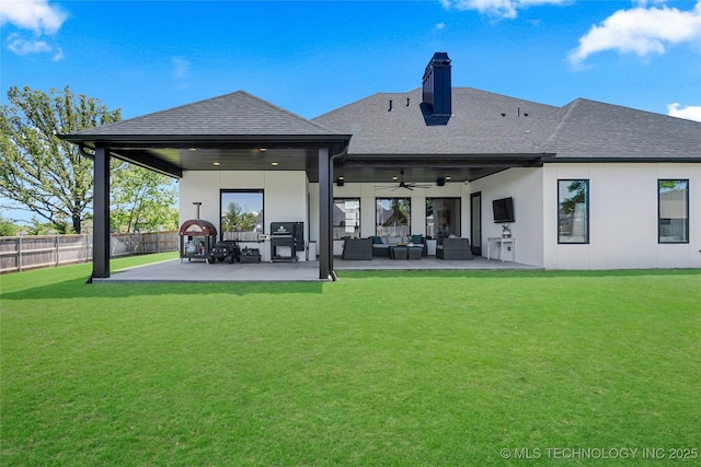 rear view of house featuring roof with shingles, fence, an outdoor hangout area, a ceiling fan, and a yard