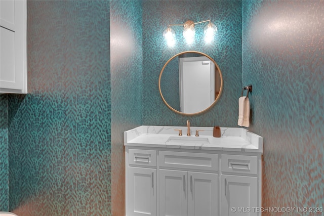 bathroom with vanity and wallpapered walls