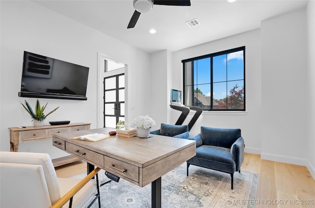 home office featuring ceiling fan, plenty of natural light, light wood-style flooring, and visible vents