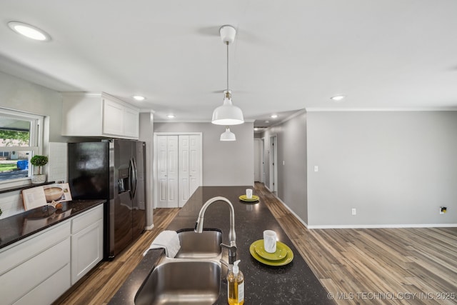 kitchen with crown molding, white cabinets, stainless steel fridge, a sink, and dark wood-style floors