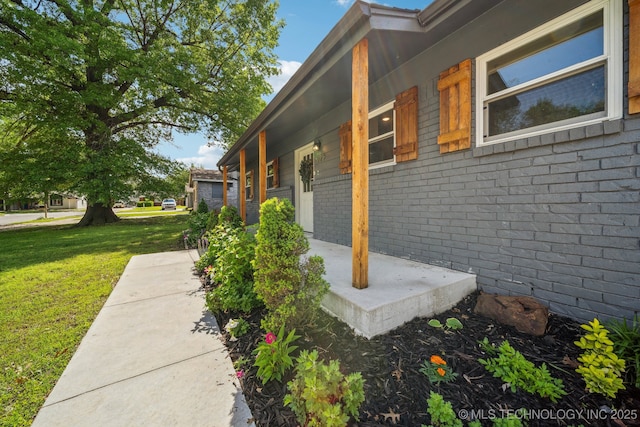 view of property exterior featuring brick siding and a yard