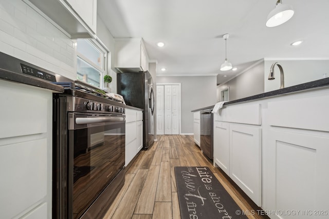 kitchen with appliances with stainless steel finishes, white cabinets, ornamental molding, and recessed lighting