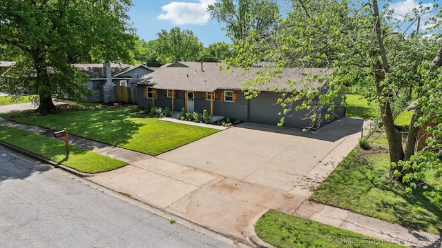ranch-style house featuring a garage, driveway, roof with shingles, and a front lawn