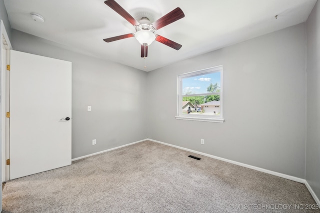carpeted empty room with a ceiling fan and baseboards