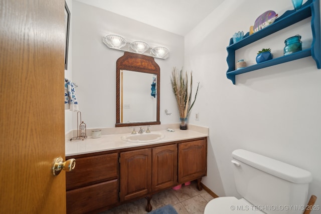 half bath with toilet, tile patterned flooring, and vanity