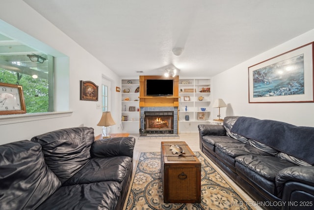 149 SE 4404th Loop, Locust Grove, OK 74352 - living room featuring wood finished floors, a lit fireplace, and built in shelves