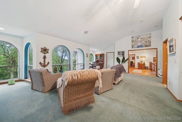 living room featuring carpet flooring, a ceiling fan, vaulted ceiling, and a healthy amount of sunlight
