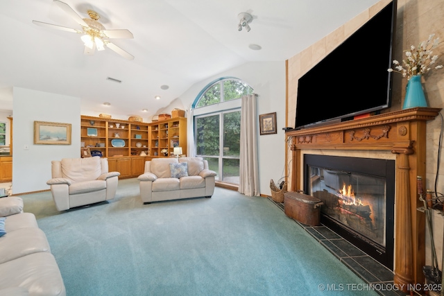 carpeted living room featuring a glass covered fireplace, ceiling fan, vaulted ceiling, and visible vents