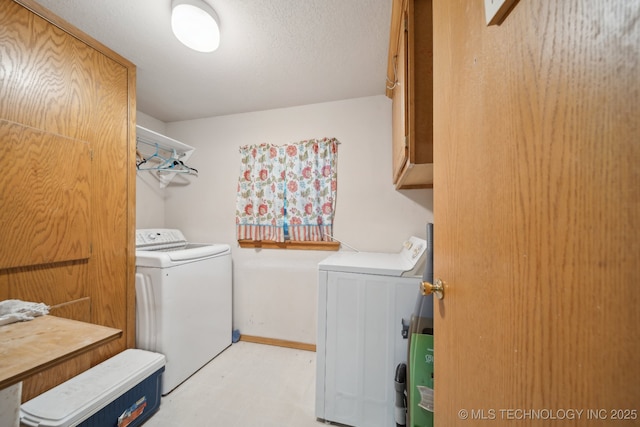 laundry room featuring light floors, baseboards, cabinet space, and washer and clothes dryer