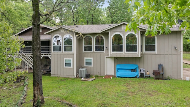 149 SE 4404th Loop, Locust Grove, OK 74352 - back of property featuring a shingled roof, a lawn, a sunroom, and stairway