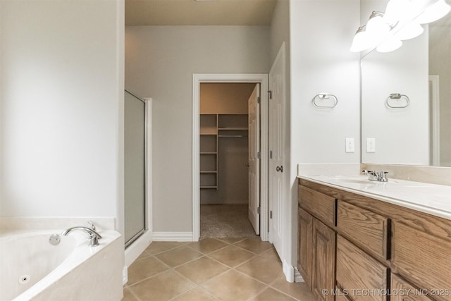 bathroom with a tub with jets, tile patterned floors, a shower stall, and vanity