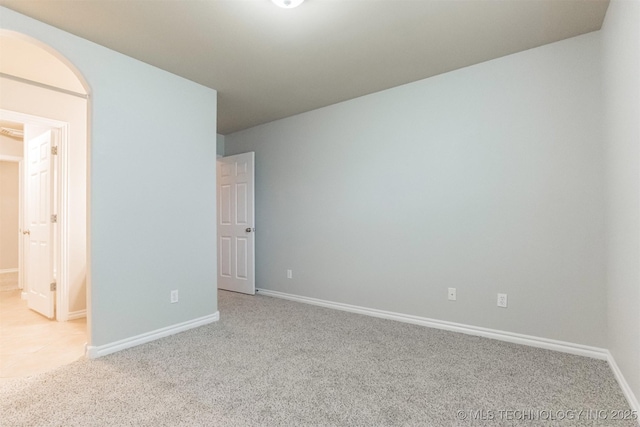 unfurnished room featuring baseboards and light colored carpet