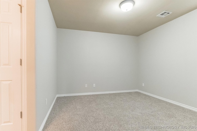 carpeted spare room featuring visible vents and baseboards