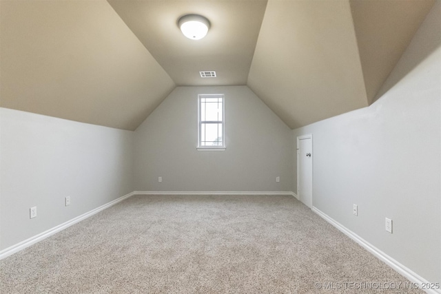 bonus room with carpet floors, baseboards, lofted ceiling, and visible vents