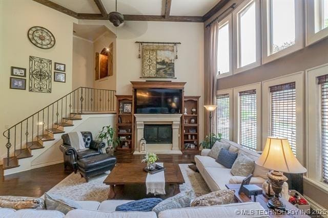 11615 S New Haven Ave, Tulsa, OK 74137 - living room featuring stairs, a glass covered fireplace, wood finished floors, baseboards, and a high ceiling