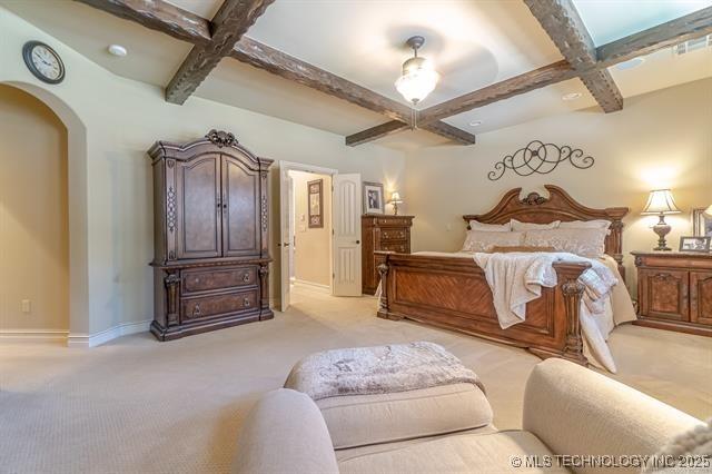 11615 S New Haven Ave, Tulsa, OK 74137 - bedroom featuring beamed ceiling, baseboards, light colored carpet, arched walkways, and coffered ceiling