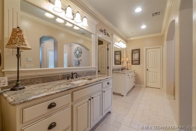 11615 S New Haven Ave, Tulsa, OK 74137 - bathroom with visible vents, two vanities, a sink, ornamental molding, and recessed lighting