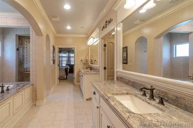 11615 S New Haven Ave, Tulsa, OK 74137 - full bath with crown molding, a sink, baseboards, two vanities, and stone tile flooring