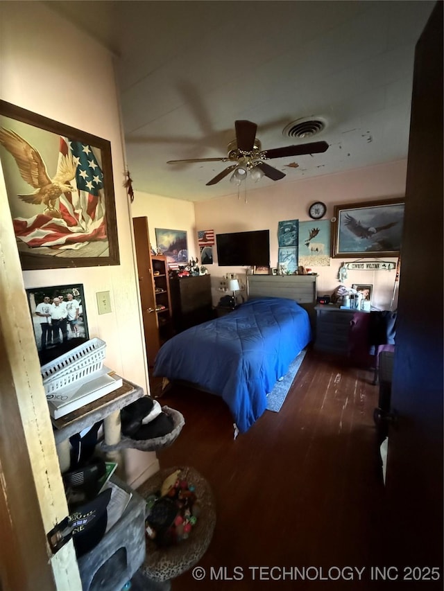 bedroom featuring ceiling fan, wood finished floors, and visible vents