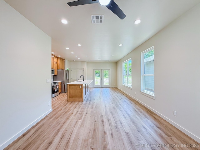 unfurnished living room featuring light wood-style floors, ceiling fan, french doors, and visible vents