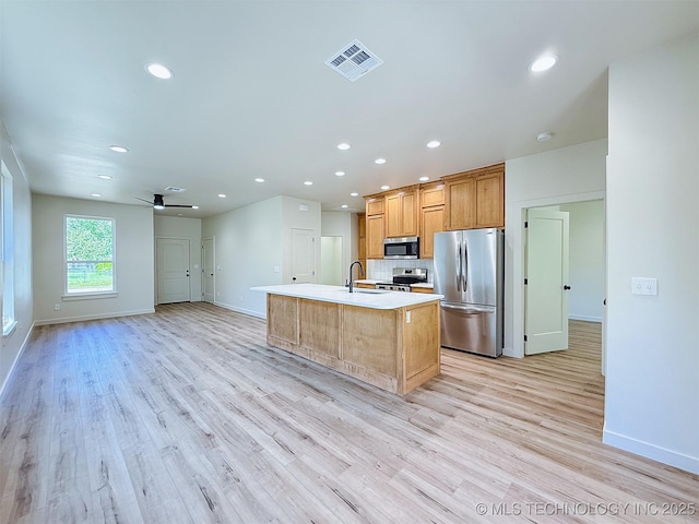 kitchen featuring visible vents, a sink, baseboards, and stainless steel appliances