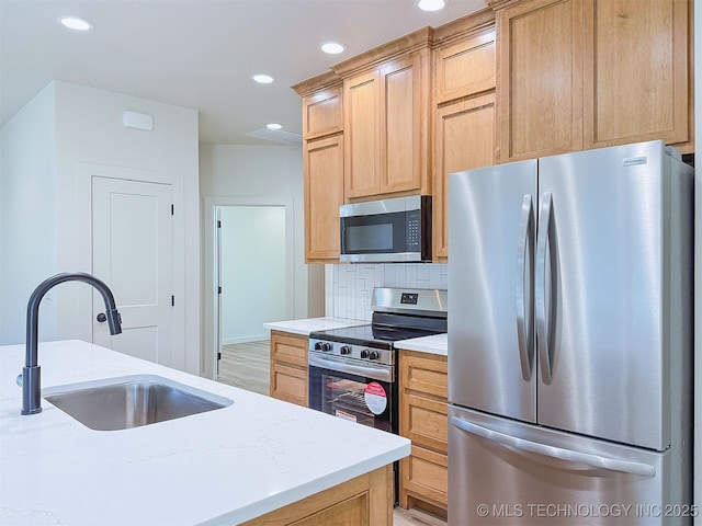 kitchen with decorative backsplash, a sink, light brown cabinets, stainless steel appliances, and recessed lighting