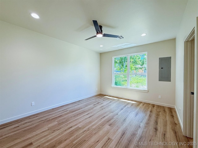 unfurnished room featuring a ceiling fan, baseboards, light wood finished floors, and electric panel
