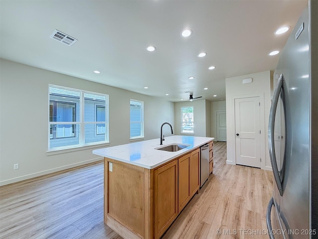 kitchen featuring visible vents, a sink, light wood-style flooring, and appliances with stainless steel finishes