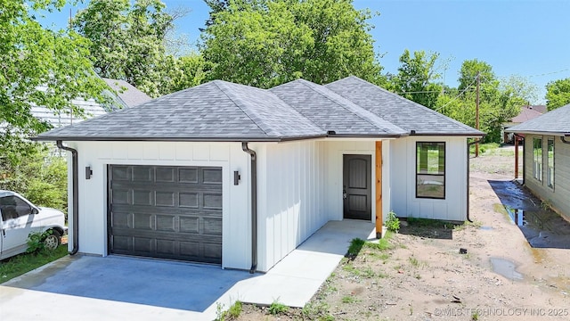 view of front of property featuring an attached garage and a shingled roof