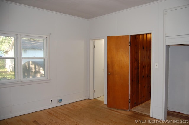 unfurnished bedroom featuring crown molding and wood finished floors